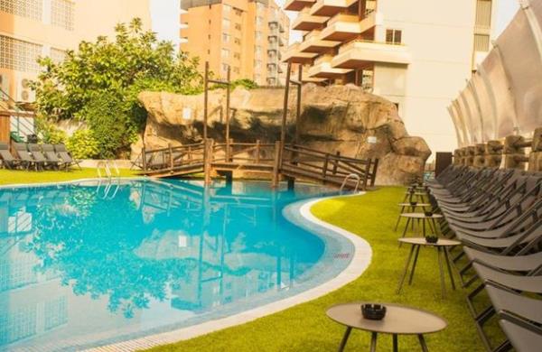 MC Music Resort in Benidorm pool with sun loungers and a bridge