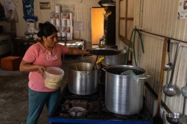 A woman cooks in the Nueva Esperanza communal kitchen in Lima's San Juan de Lurigancho district.